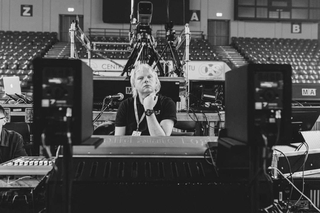 Patryk Tylza at the mixing console in an arena before a show, black and white