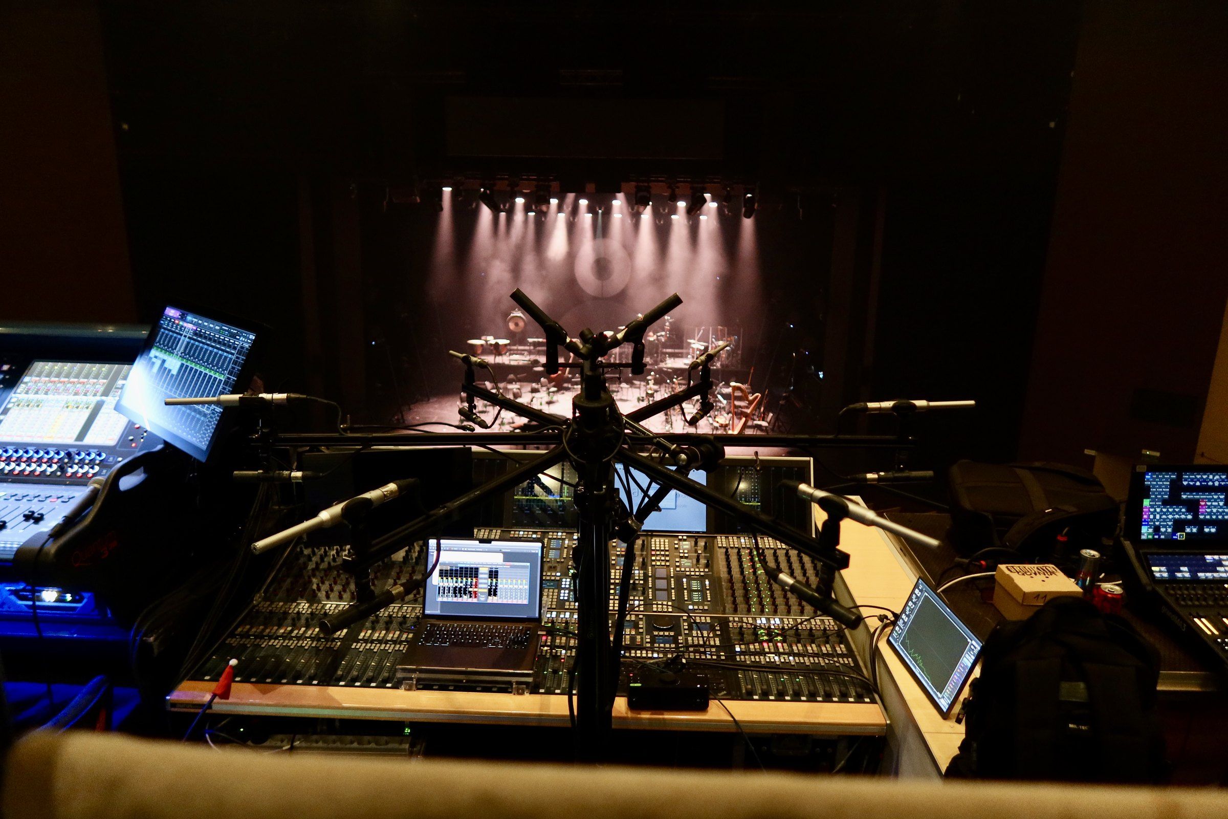 Recording position with a console and microphone array, the lit stage behind